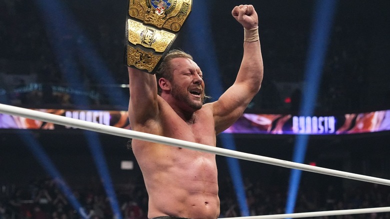Kenny Omega celebrates with his title