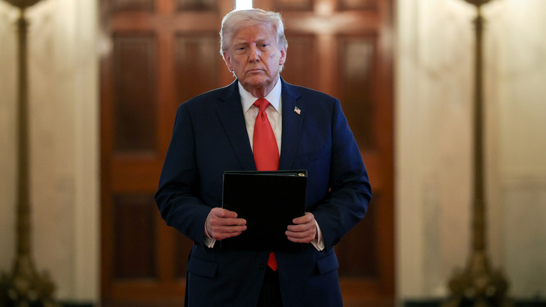 President Donald Trump walks down a hallway in The White House
