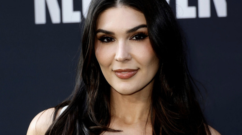 Cathy Kelley smiles in a white dress as she appears at a red carpet event for Receiver.