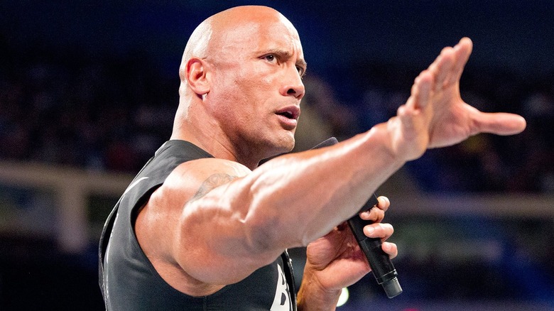 The Rock raising his arm outward