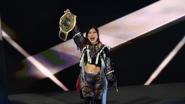 IYO SKY holding the title high above her head