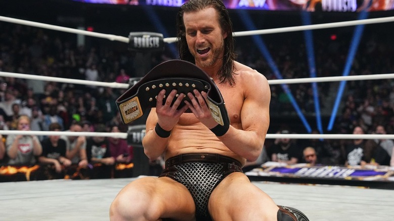 Adam Cole stares at his newly-won TNT Championship at AEW Dynasty