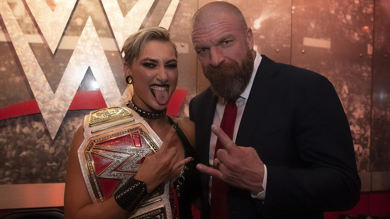 Rhea Ripley poses beside Triple H backstage in gorilla position after winning the "WWE Raw" Women's Championship.