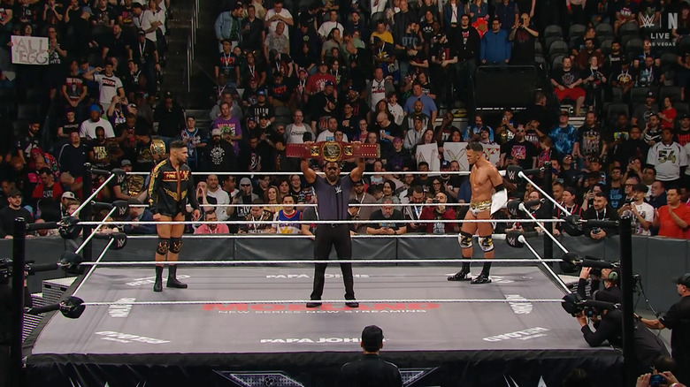 Saints and Page staring each other down as the referee holds up the North American Championship