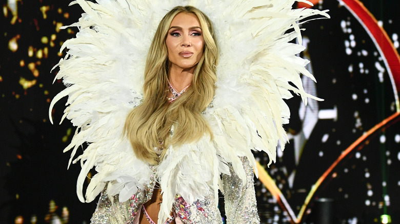 Charlotte Flair wearing extravagant gear with white feathers